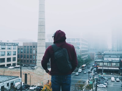 男人俯视这座城市覆盖着雾白天
